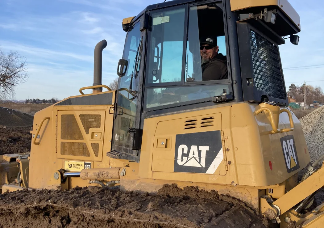 Employee smiling while working in CAT excavator