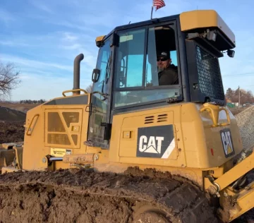 Employee smiling while working in CAT excavator