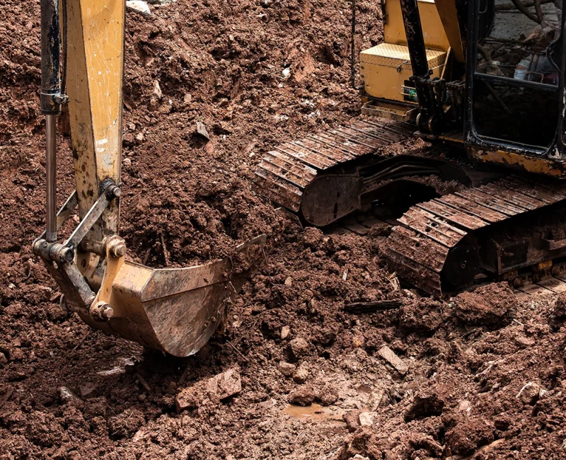 excavator digging trench for a gravity irrigation system